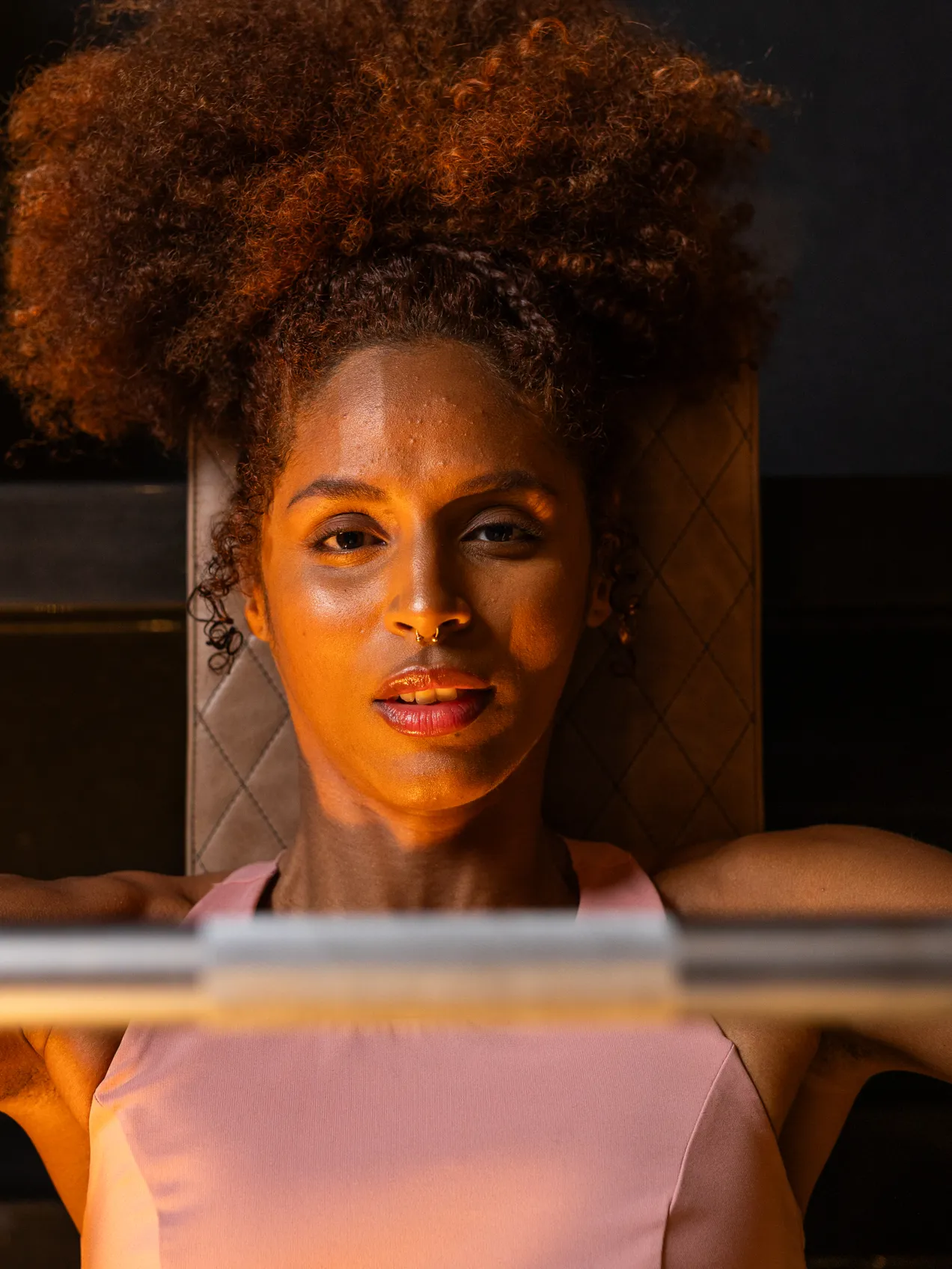Female gym member completing a bench press exercise.