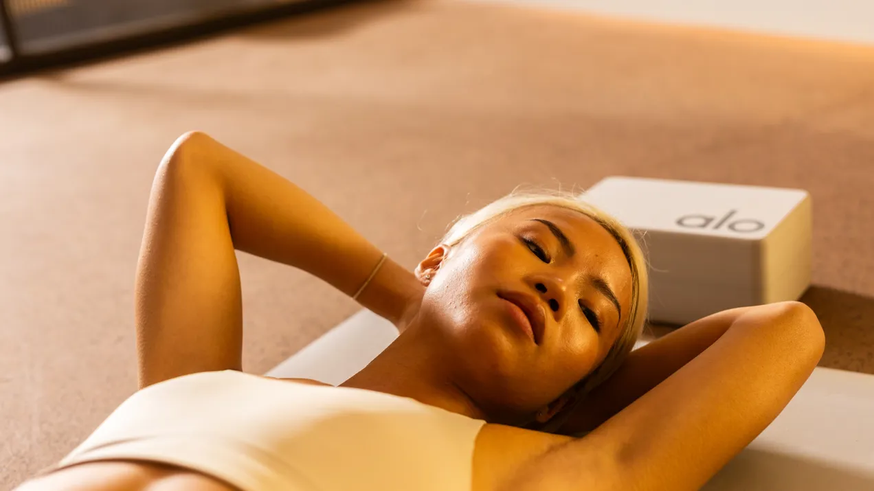 Female gym member lying on a yoga mat, post workout.